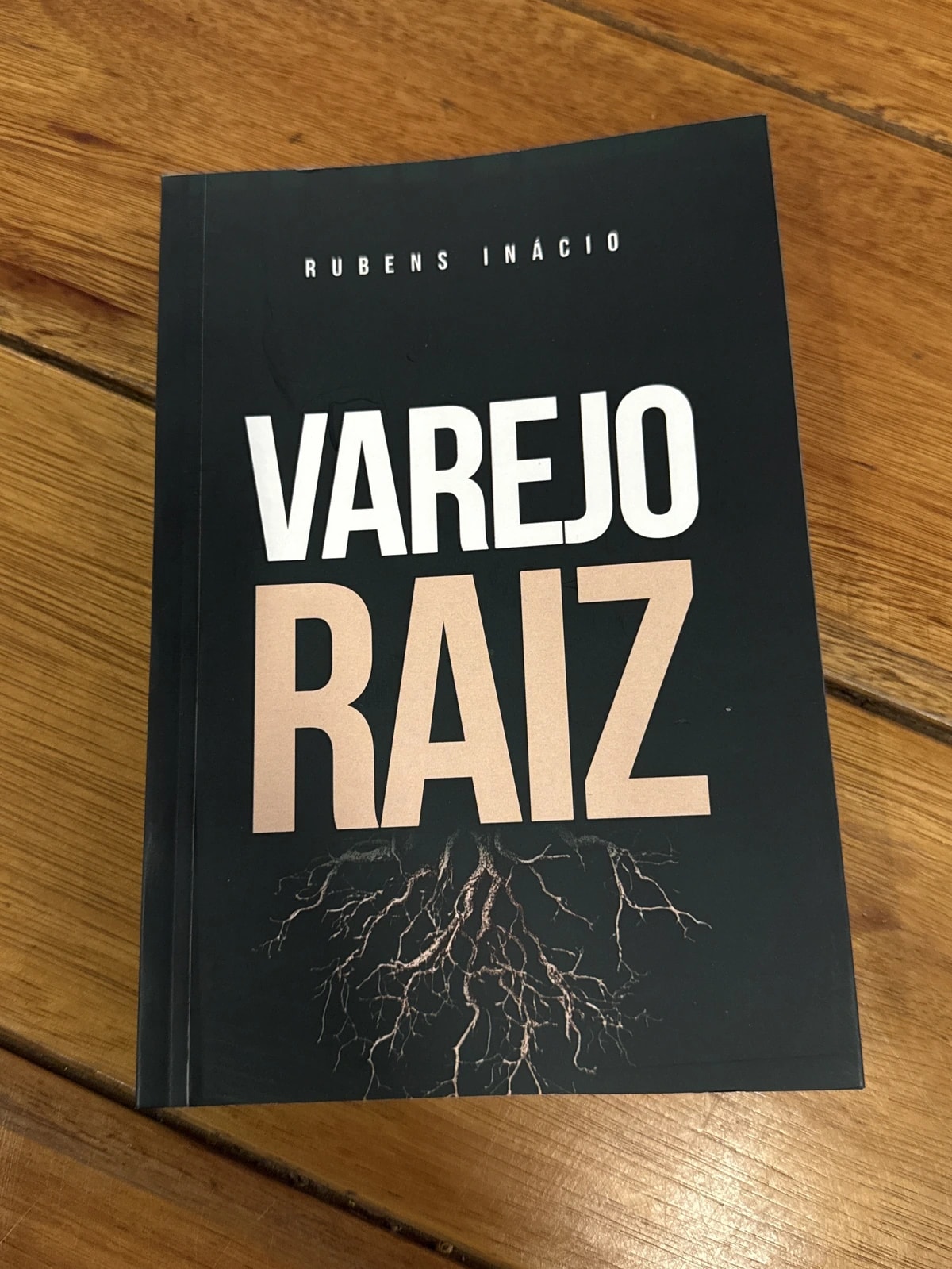 O livro Varejo Raiz apoiado sobre uma mesa de madeira